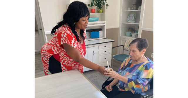Staff member serves a snack to a memory care resident at Trinity Springs.