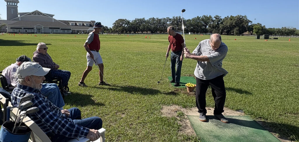 Residents participate in golf activity as part of memory care programming at Trinity Springs supporting engagement and physical activity.