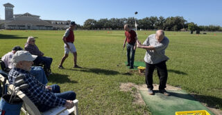 Residents participate in golf activity as part of memory care programming at Trinity Springs supporting engagement and physical activity.