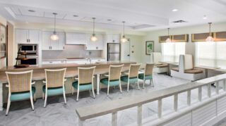Bistro-style dining area with booth seating, communal tables, kitchen island, pendant lighting, and open gathering space at Trinity Springs