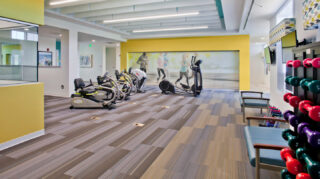 Fitness center with cardio equipment, free weights, televisions, and open workout space designed for wellness and exercise at Trinity Springs