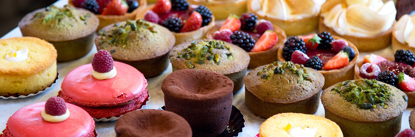 Assorted desserts including fruit tarts, cupcakes, macarons, and pastries, representing dining experiences and sweet treats like at Trinity Springs