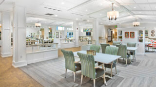 Open dining and gathering space with tables, upholstered chairs, decorative shelving, natural light, and multiple seating areas at Trinity Springs