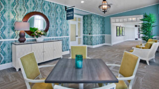 Fitness center entrance with nearby seating area, decorative furnishings, patterned wall accents, and access to wellness amenities at Trinity Springs