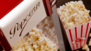 Popcorn machine and fresh popcorn, representing movie nights and entertainment opportunities like at Trinity Springs