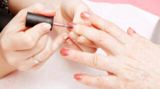 Close-up of a manicure service with nail polish being applied, representing salon and personal care services like at Trinity Springs