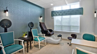 Salon spa room with shampoo station, drying chairs, manicure table, comfortable seating, and large window at Trinity Springs
