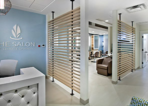 Salon and spa entrance with reception desk, styling stations, treatment areas, decorative partitions, and personal care services at Trinity Springs