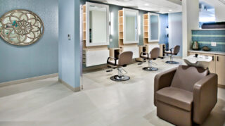 Salon with styling stations, mirrors, salon chairs, wash basin, cabinetry, and personal care amenities at Trinity Springs